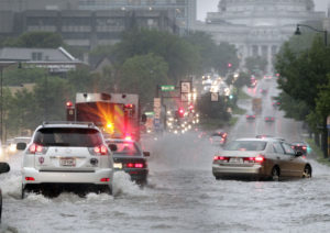 Motorists and a fire engine brave high water on East Washington Avenue between the cross streets of Blount and Livingston Streets after a strong storm dumped large amounts of rain in Madison on June 30, 2014.  Storms in the warmer, moister atmosphere of the future have the potential to be more severe than otherwise similar storms today.  (Photo credit:  M. P. King, State Journal archives)